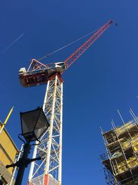 Low angle view of crane against blue sky