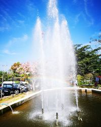 Water splashing fountain against sky