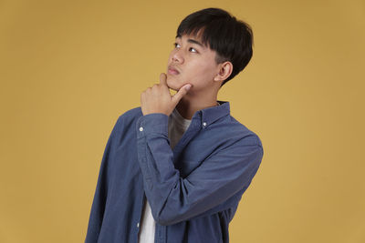 Young man looking away against white background