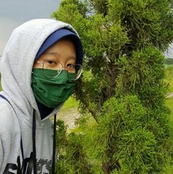 Portrait of girl wearing sunglasses against plants