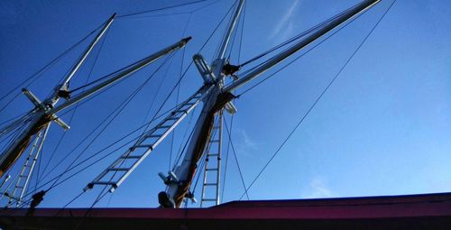 Low angle view of sailboat against blue sky