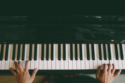 Midsection of young woman playing piano