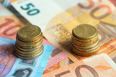 High angle view of coins over paper currency