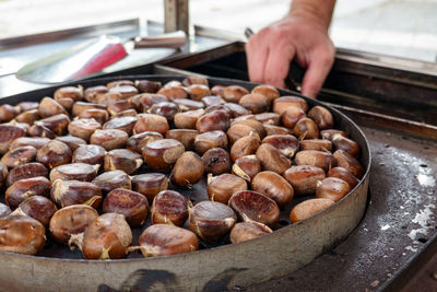 Close-up of person preparing chestnuts in container