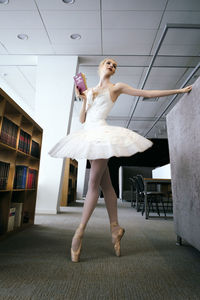 A charming ballerina went to the library to choose a new book during a break