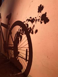 Silhouette bicycle against wall during sunset