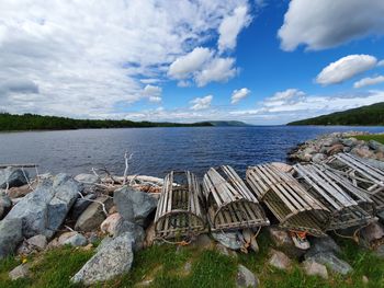 Scenic view of sea and lobster pots against sky