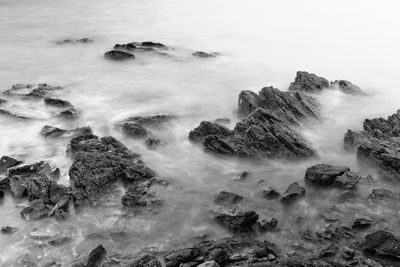 Scenic view of rocks in sea against sky