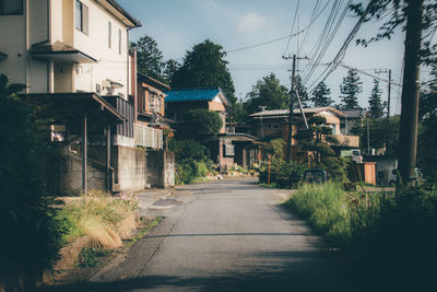 Street amidst trees against sky