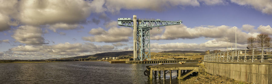 Panoramic view of harbor at river against sky