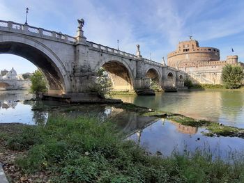 Arch bridge over river against sky