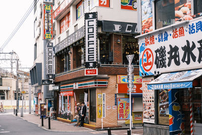 People walking on street against buildings in city