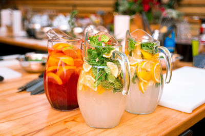 Soft drinks citrus lemonades in large glass jugs on the table