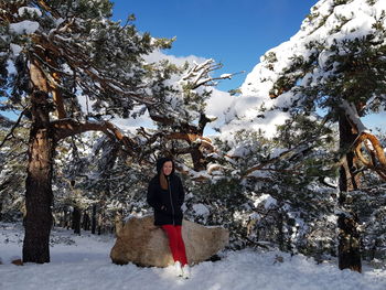 Full length of woman standing on snow covered trees