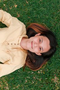 Portrait of smiling woman lying on grass