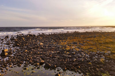 Scenic view of beach and sea against cloudy sky