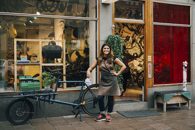 Portrait of young woman standing at store