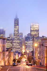 Illuminated buildings in city against sky at night