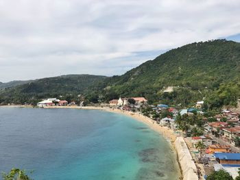 High angle view of town by sea against sky