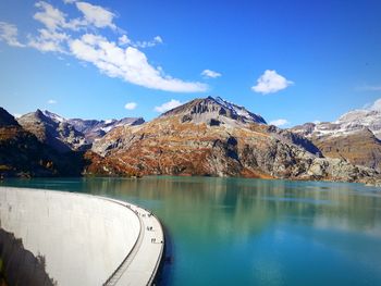 Scenic view of lake by mountains against sky