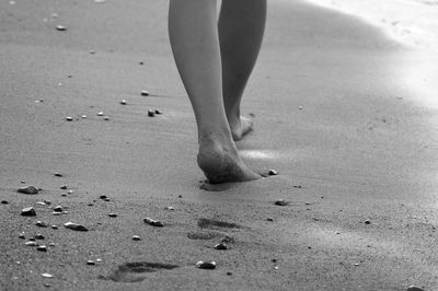 Low section of man standing on beach