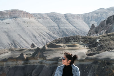 Portrait of woman standing against mountain