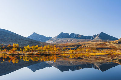 Reflection of rondane mountains in a small lake. rondane national park, norway, europe autumn colors