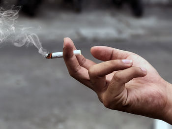 Cropped image of hand holding cigarette