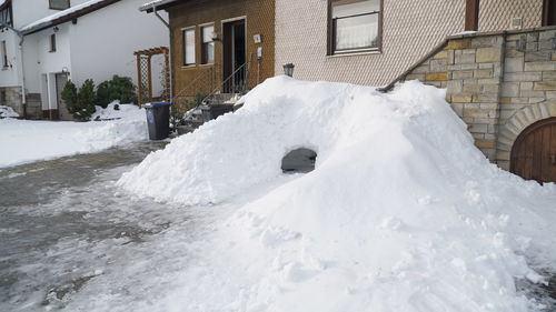 Snow covered houses against buildings