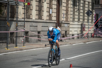 Man riding bicycle on road in city