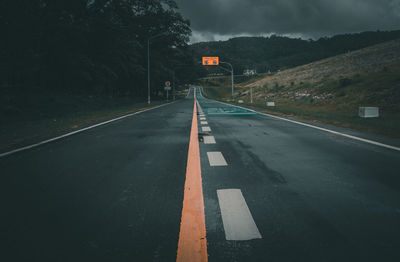 Empty road against mountains at dusk