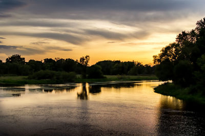 Scenic view of lake against sky at sunset