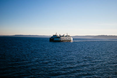 Ship sailing on sea against clear sky