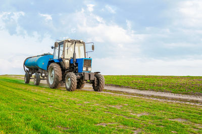 Tractor on agricultural field against sky