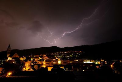 Lightning over illuminated cityscape at night