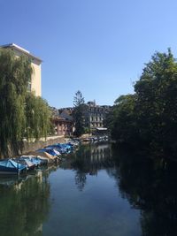 Boats moored in river with buildings in background