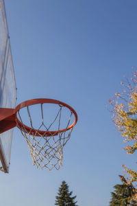 Low angle view of basketball hoop against clear blue sky