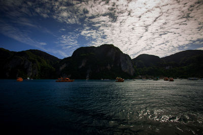 Scenic view of sea and mountains against sky