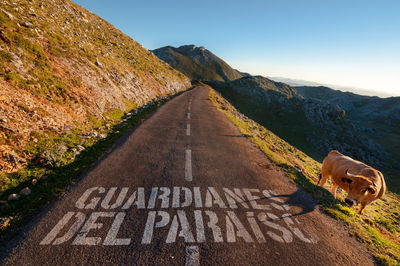 Road leading towards mountain against sky