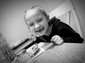 Portrait of smiling boy on table at home