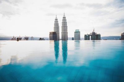Reflection of buildings in infinity pool against sky