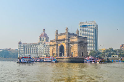 Boats in river with buildings in background