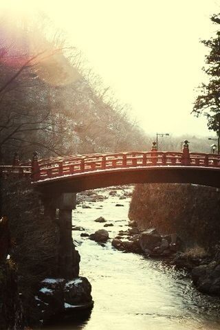 bridge - man made structure, connection, built structure, architecture, water, clear sky, bridge, river, rock - object, arch, arch bridge, sunlight, engineering, transportation, nature, tranquility, outdoors, sky, no people, low angle view