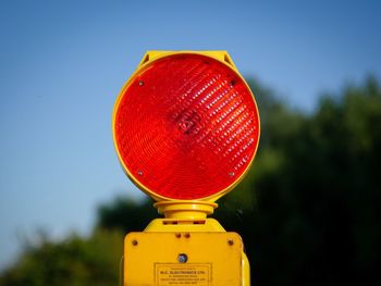 Close-up of road sign against clear blue sky