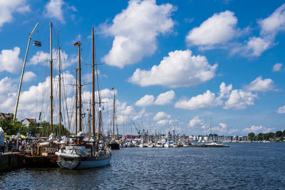 Sailboats in harbor against sky