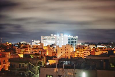 High angle view of buildings in city against storm clouds