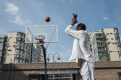 Young man throwing basketball in hoop