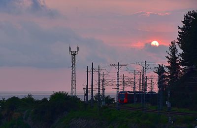 Electricity pylon against sky during sunset