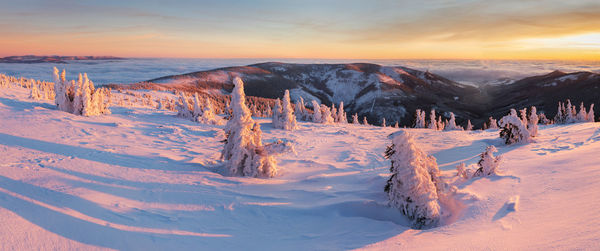 Panoramic view of snowcapped mountains against sky during sunset