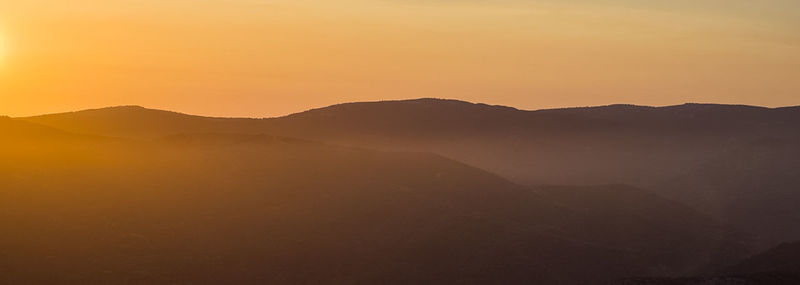 Scenic view of silhouette mountains against sky during sunset